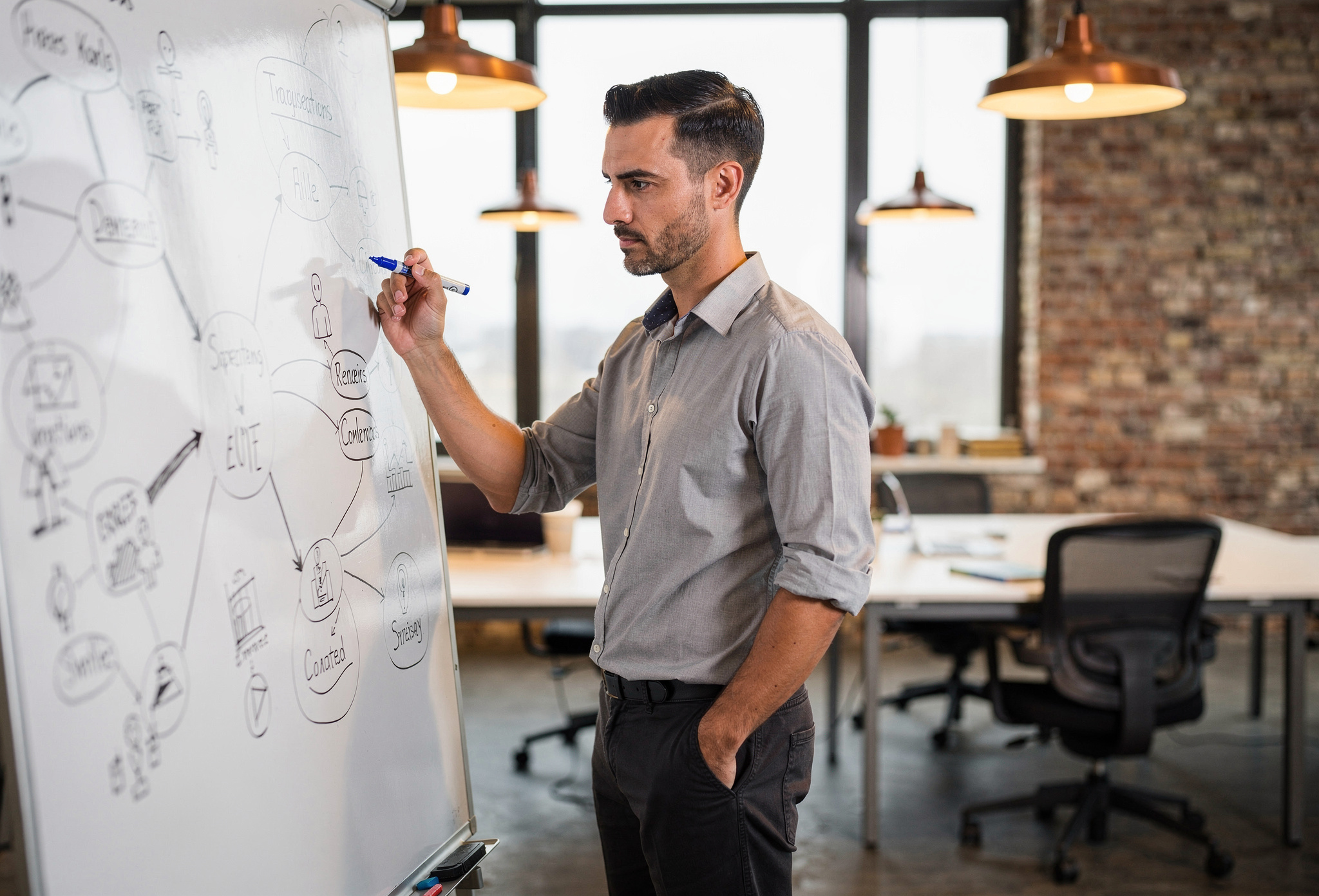 Otuzlu yaşlarında adam beyaz tahtada kariyer planı çizimi yapıyor modern co-working alanda